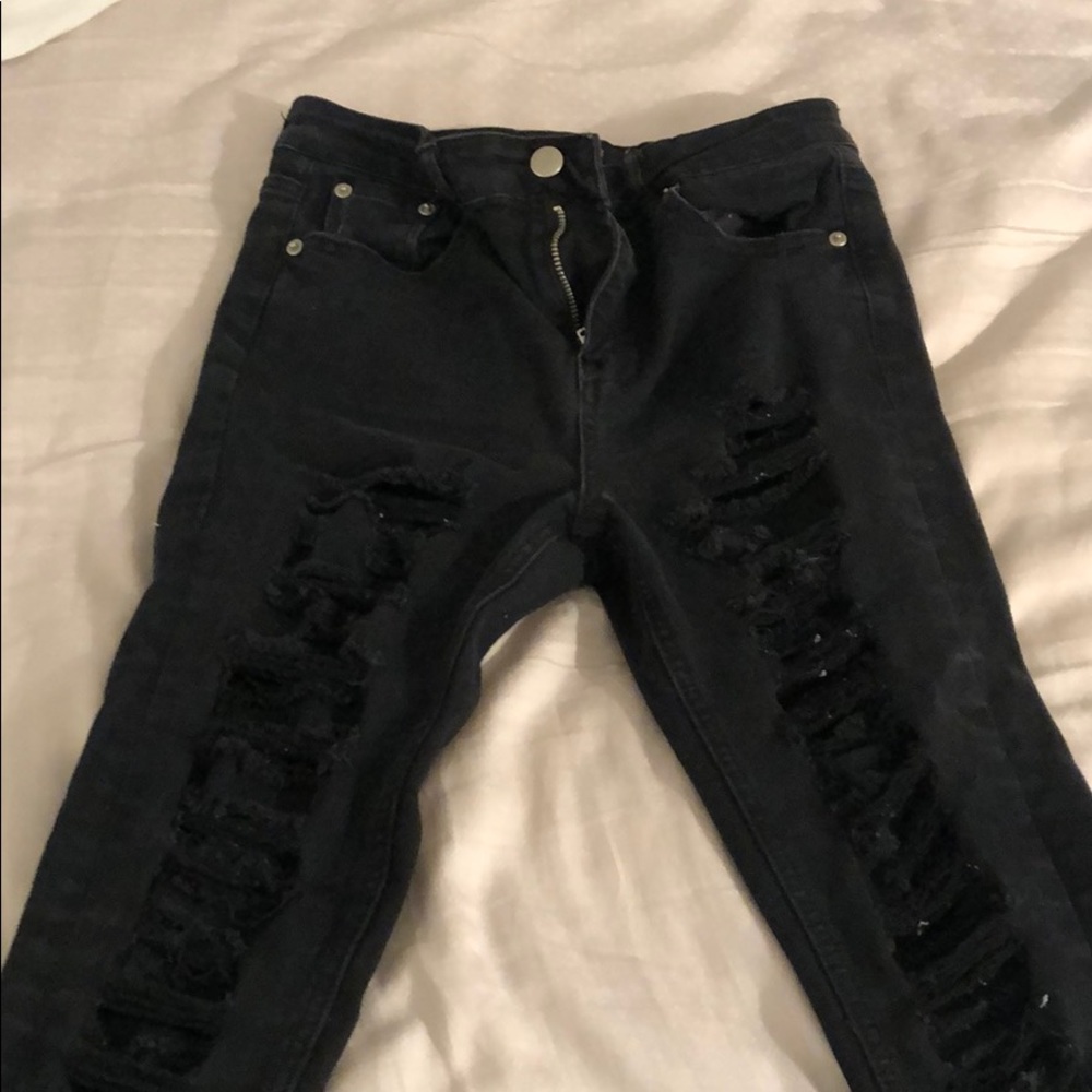 Black ripped jeans all down the front of the legs